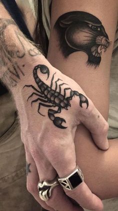 a man with a scorpion tattoo on his hand