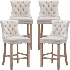 a set of four white upholstered barstools with studded trimmings