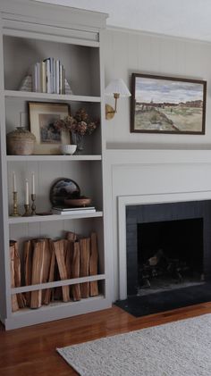 a living room filled with furniture and a fire place in front of a book shelf