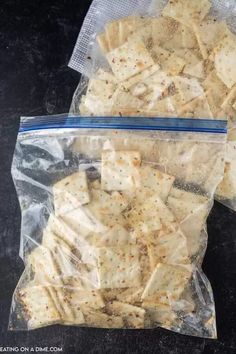 two bags filled with crackers sitting on top of a black counter next to each other