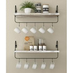 two shelves with cups and coffee mugs on them, one shelf is hanging from the wall