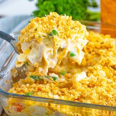 a casserole dish with chicken and vegetables being lifted from the casserole