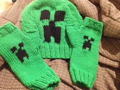 two green knitted sweaters with black letters on them