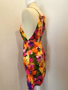 "Original to the 60s. Fab MINI Dress!! Bright bold floral pattern. Front cut out detail at chest, toe back neck, hidden back zipper and button closure. Mannequin is a US Size 4, and the dress fits her like a glove, for your sizing reference. Measurements laying flat - The high waist is empire style and hits just below the bust. Measures 13\" laying flat. Total length of dress is 31\" (mini dress) The halter style neck ties at back Tiki Time!" Fitted Floral Print Backless Mini Dress, Fitted Halter Neck Floral Dress, Summer Floral Print Mini Dress For Cocktail, Summer Floral Print Cocktail Mini Dress, Vintage Summer Floral Dress For Party, Vintage Floral Dress For Summer Party, Fitted Halter Neck Dress With Tropical Print, Vintage Backless Party Dress, Fitted Halter Neck Floral Dress For Garden Party