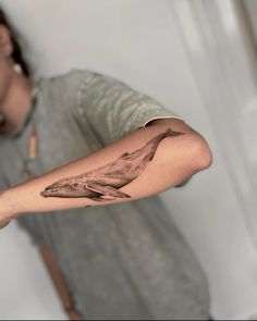 a man with a whale tattoo on his arm