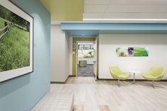 an office hallway with chairs and pictures on the wall