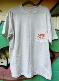 1991 Club Camel Member pocket tee. Size XL, single stitch throughout, front pocket print and large (vibrant and awesome) back print. Minor yellowing on certain areas of the shirt, might come out with an oxi bath. Cotton Camp Shirt With Graphic Print For Streetwear, Vintage Graphic Print Camp Shirt For Streetwear, Cotton Crew Neck Camp Shirt With Graphic Print, 90s Style Camp Shirt With Graphic Print, 90s Graphic Print Camp Shirt With Short Sleeves, 90s Style Short Sleeve Camp Shirt With Graphic Print, 90s Streetwear Tops With Pockets, 90s Style Streetwear Tops With Pockets, Joe Cool