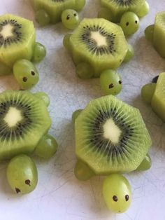 sliced kiwis and grapes on a white surface