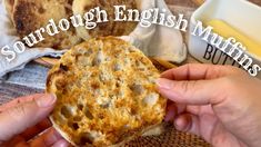 two hands holding up a pastry in front of bread and butter on a table with the words sourdough english muffins written above it