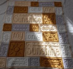 a crocheted blanket with letters and numbers is shown on a bed sheet that has been made into a quilt