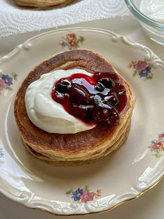 a stack of pancakes topped with whipped cream and jelly