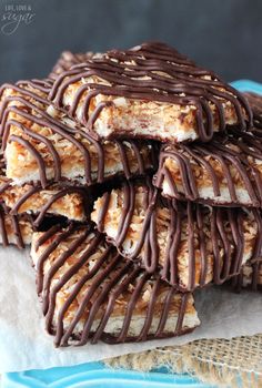 chocolate and coconut bars stacked on top of each other with drizzled chocolate