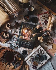 there is a book on the table next to some candles and other things in front of it