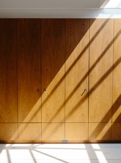 an empty room with wooden cabinets and sunlight coming through the window