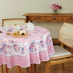 the table is set with tea and pastries on it, along with two chairs