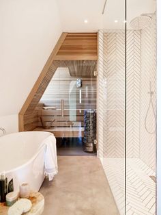 a bathroom with a white bath tub sitting next to a walk in shower and wooden ceiling