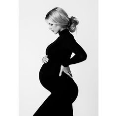 a pregnant woman poses for a black and white photo with her hands on her hips