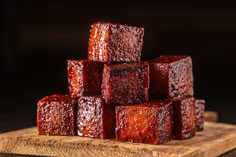 several cubes of food sitting on top of a wooden cutting board next to each other