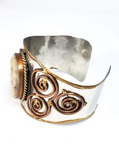 Stunning handcrafted Tri metal cuff with a large jasper center cabochon. This artisan piece has non magnetic silver plate with copper edging and twisted rope accents. There are trillion shaped swirled brass designs expertly welding into the base. Has Mexican artistic elements. These artists were known for making exceptional Brutalist style jewelry. Bracelet measures just over 2 inches thick and 7 and 1/2 inches in wearable circumference. Artistic Elements, Cuff Bracelet, Cuff Bracelets, Silver Plate, Fashion Jewelry, Copper, Cuff, Brass, Bracelet