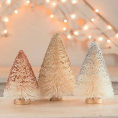 three small christmas trees sitting on top of a table