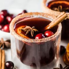 two glasses filled with liquid and cinnamon sticks