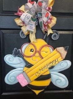 a door hanger with a bee and pencils on it