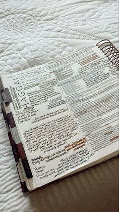 an open bible sitting on top of a bed