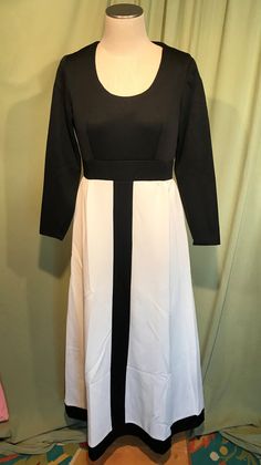 "This is a cute vintage dress from the 70's. No labels or tags. The bust measures 36\", waist 30\", see measurements below. Made of a black & white polyester. The dress is maxi length & it is not lined. It has long sleeves with small vents in the cuff edge seams. The top half & center stripe on the skirt are plain black & the skirt is plain white. Neckline is a scoop neck. Zips in the back with a nylon zipper. The dress is in very good condition, no wear or tear. No soil or stain Elegant Black Dress With Modesty Panel, Modest Black A-line Dress, White Retro Midi Dress For Party, White Fitted Retro Maxi Dress, Modest Fitted Black Midi Dress, Black Vintage Long Sleeve Maxi Dress, Formal Fitted Dress With Modesty Panel, White Vintage Midi Dress For Evening, Vintage White Evening Midi Dress