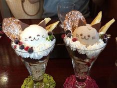 two dessert sundaes with whipped cream and fruit