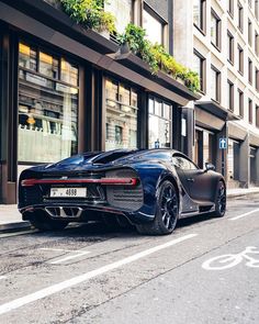 a bugatti is parked on the side of the road in front of a building