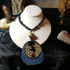 a necklace with an animal print pendant on top of a mannequin's head