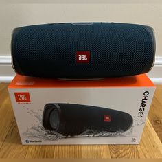 the jbl charge 4 portable bluetooth speaker is on top of an orange box