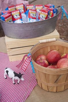 a basket full of apples sitting on top of a table next to a bag of candy