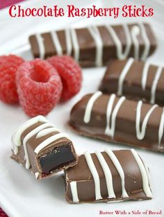 chocolate raspberry sticks on a white plate with raspberries in the background