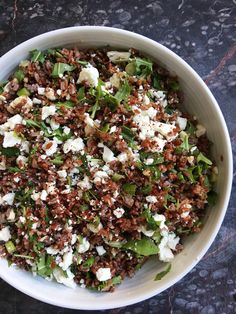 a white bowl filled with lots of food on top of a table