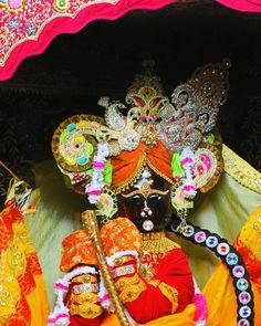 an elaborately decorated mask and headdress on display at a festival in india