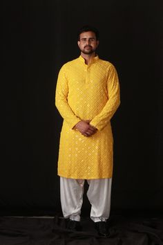 An unconventional interplay of Indian heritage , this sartorial piece exudes a fluid energy with it's lakhnavi pattern. Design elements like mirror work detailing gives an edgy touch to the ensemble.  Components : 2 Fabric : Lakhnavi (Kurta), Satin Silk (Patiala) Neckline : Mandarin Collar Color : Yellow Kurta Pajama Men Haldi Function, Patiyala Kurta For Men, Kurtas For Haldi For Men, Yellow Haldi Outfit For Men, Yellow Kurta Pajama Men, Haldi Dress For Men Yellow, Kurta For Haldi Function Men, Yellow Kurta Men For Haldi, Haldi Kurta For Men