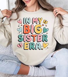 Celebrate the joy of siblinghood with this "In My Big Sister Era" sweatshirt. Perfect as a special gift for little girls stepping into their big sister role. This fun, colorful, and playful design will become a treasured piece in their wardrobe, making every outing an opportunity to share their excitement. Introducing our cozy Crewneck Sweatshirt, the ultimate blend of style and comfort. This soft and inviting sweatshirt is perfect for chilly days, providing a warm hug against the cold. Made for trendsetters and comfort-lovers alike, it fits seamlessly into your casual wardrobe, whether you're out running errands or lounging at home. Celebrate special moments with this versatile piece, ideal for family gatherings, birthdays, or creating cherished memories during holidays. With its fun desi Big Sis Embroidered Sweater, Best Big Sister Shirt, Big Sister Again Shirt, I’m A Big Sister Shirt, Bigger Sister Big Sister Shirts, Cute Sister, New Sibling, Big Sister Gifts, Sibling Outfits