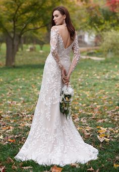 a woman in a wedding dress standing on the grass