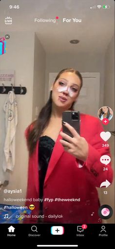 a woman is taking a selfie in the mirror with her cell phone while wearing a red blazer