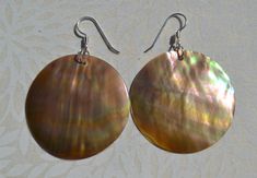 These beautiful earrings feature a carved disc brown mother of pearl shell. . The iridescence of the Mother of Pearl Shell l is really amazing. Depending on the light source they will radiate colors varying from browns to pinks . The shells are then polished to a high gloss to reveal the beauty of their natural pattern. Enjoy these lightweight beauties that are so easy to wear.These beach earrings are perfect for everyday and any occasion. DETAILS - Shell types :Brown Mother of Pearl Shell - Mat Mother Of Pearl Earrings With High Luster For Gifts, Handmade Brown Shell As Gift, Handmade Brown Shell As A Gift, Handmade Brown Shell For Gift, Handmade Brown Shell Gift, Handmade Mother Of Pearl Round Pearl Earrings, Handmade Round Mother Of Pearl Earrings, Elegant Brown Mother Of Pearl Jewelry, Iridescent Mother Of Pearl Drop Earrings