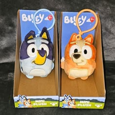 two stuffed animals are in the packaging for this toy, one has a keychain on it