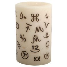 a white candle with black writing on it and symbols around the candlestick is shown in front of a white background