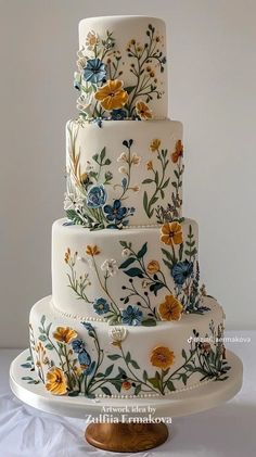 a three tiered wedding cake with flowers painted on it