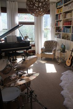 a living room filled with lots of furniture and a piano in front of a window