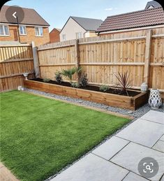 a backyard with grass and wooden fenced in area next to the yard is an artificial lawn