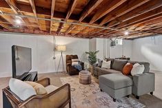 a living room with couches, chairs and a television on the wall in it