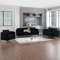 a living room filled with black couches and chairs next to a white rug on top of a hard wood floor