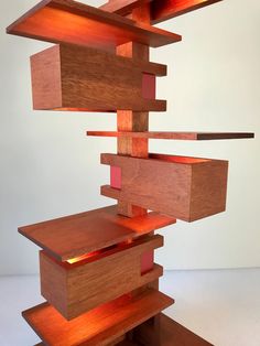 a wooden sculpture with red light coming out of it's top and bottom part