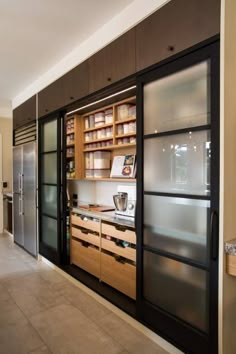 a large kitchen with lots of wooden cabinets and glass doors on the front wall, along with stainless steel appliances